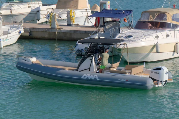 İtalya, Sicilya, Akdeniz, Marina di Ragusa (Ragusa Eyaleti); 23 Ekim 2022, limandaki kauçuk bir teknede adam - EDITORIAL