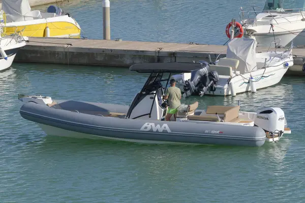 İtalya, Sicilya, Akdeniz, Marina di Ragusa (Ragusa Eyaleti); 23 Ekim 2022, limandaki kauçuk bir teknede adam - EDITORIAL