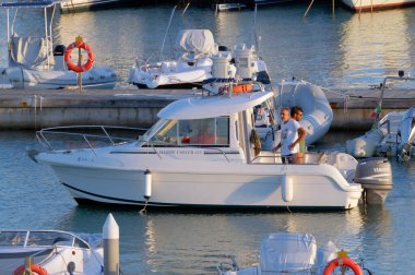 İtalya, Sicilya, Akdeniz, Marina di Ragusa (Ragusa ili); 23 Ekim 2022, limandaki bir motorlu teknede erkekler - EDITORIAL