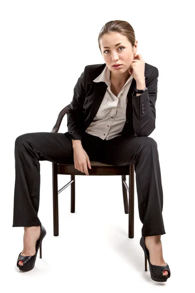 Businesswoman sitting on a chair isolated on white — Zdjęcie stockowe