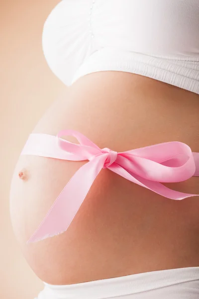 Ventre enceinte avec ruban rose Image En Vente