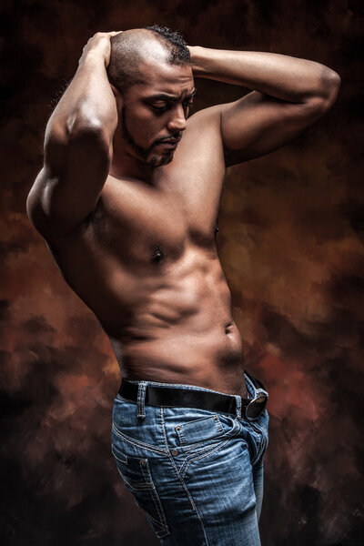 Naked man with perfect body posing in jeans