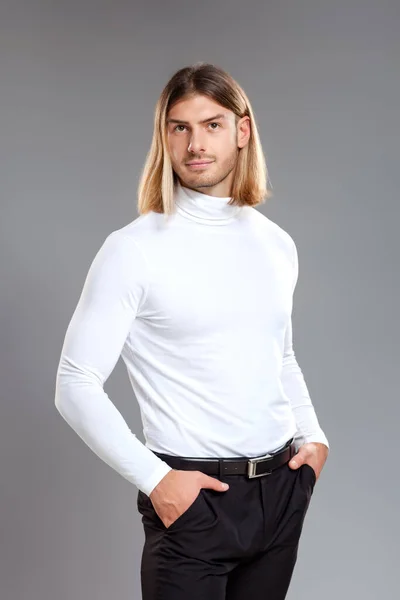 Männermode, Schönheitskonzept. Porträt eines jungen Mannes mit blonden Haaren, der vor grauem Hintergrund posiert. Klassischer Stil. Studioaufnahme — Stockfoto