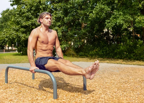 Young man exercises sports In the park - fitness concepts.