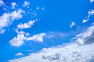 Blue sky background with the sunny summer clouds