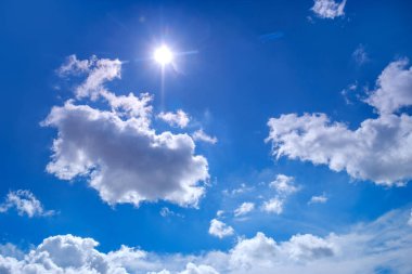 Blue sky background with the sunny summer clouds