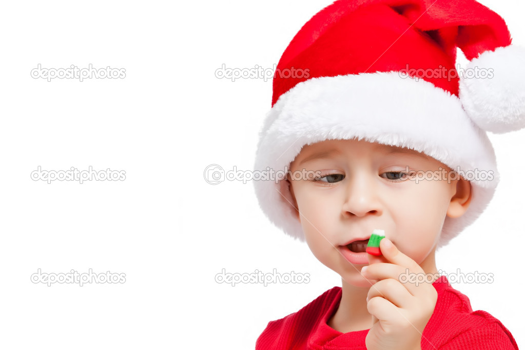 a little boy with   santa hat holding   candy