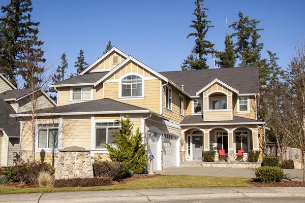 Small beige  brick home  with a two car garage in the front 