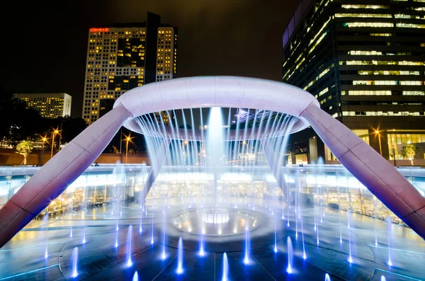 SINGAPOUR-JAN 24 : Fontaine de richesse avec tours Suntec au crépuscule — Photo