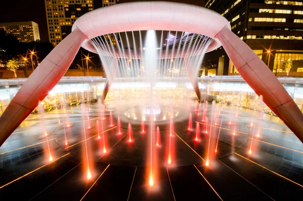 SINGAPORE-JAN 24: Fontana della Ricchezza con Torri Sunteche al tramonto — Foto Stock