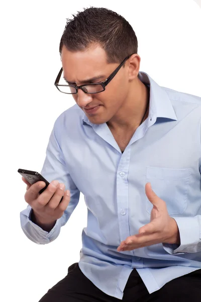 Человек раздражен своим мобильным телефоном — стоковое фото