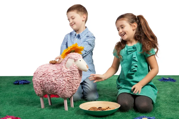 Bambini che ridono giocando con una pecora giocattolo — Foto Stock