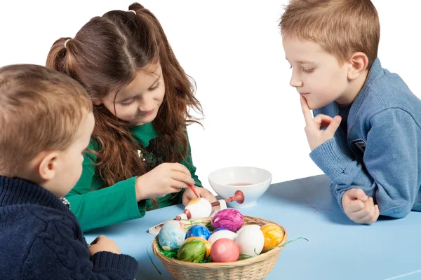 Drie kinderen schilderij paaseieren — Stockfoto