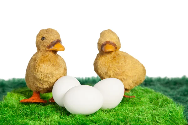 Two yellow toy chicks with three eggs — Stock Photo, Image
