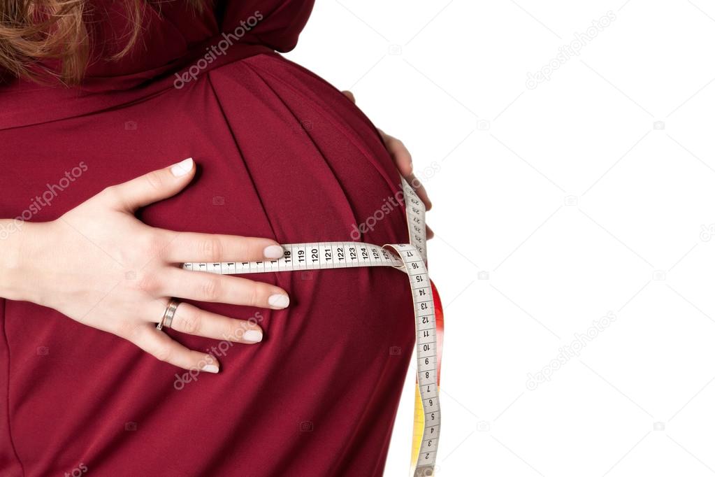 Pregnant woman measuring her belly