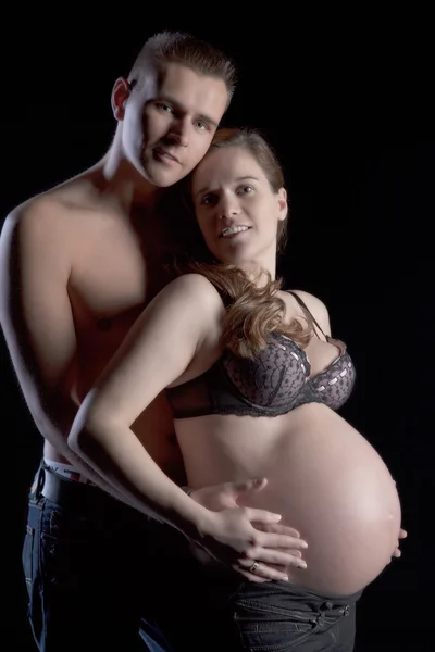 Young man holding his pregnant wife — Stock Photo, Image