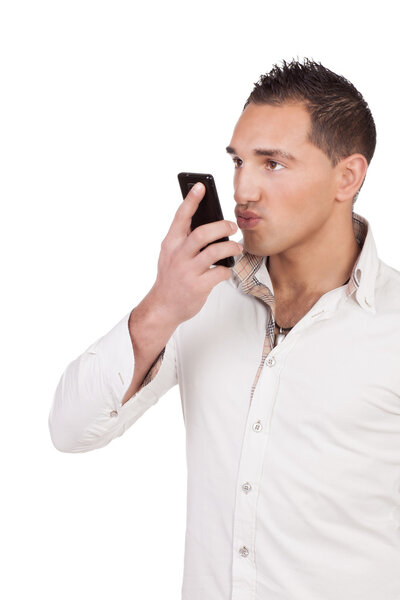 Человек, дующий поцелуй в свой мобильный телефон
