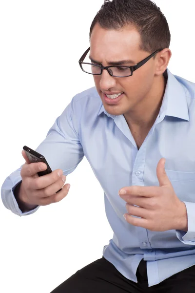 Angry young man kijken naar zijn mobiele telefoon — Stockfoto