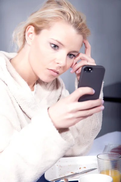 Halv vaken kvinna som tittar på sin mobil — Stockfoto