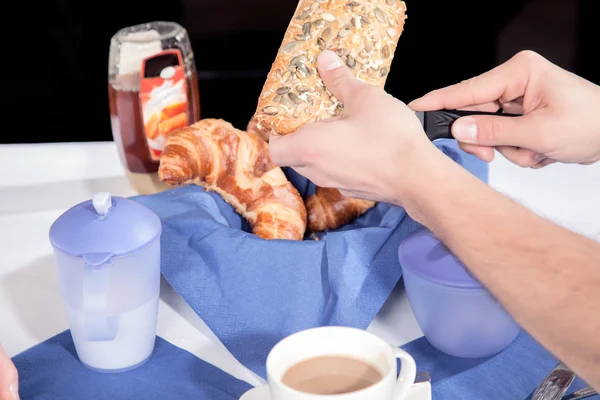 Man slicing a wholewheat roll — Stock Photo, Image