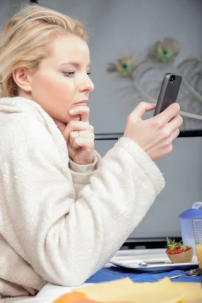 Tankeväckande kvinna läser en mobiltelefon meddelande — Stockfoto