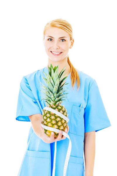 Krankenschwester hält Ananas mit Maßband umwickelt — Stockfoto