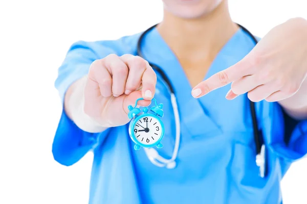 Midsection sjuksköterska pekar på leksak väckarklocka — Stockfoto