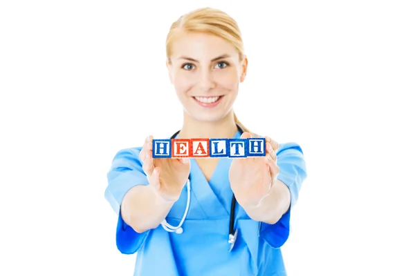 Nurse Holding Blocks Spelling Out Health Over White Background — Stock Photo, Image