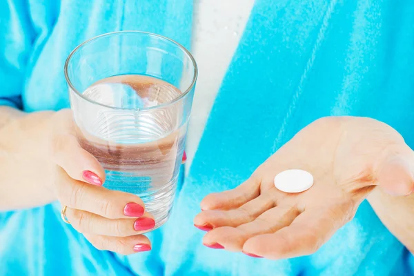 Mujer mayor sosteniendo medicina y vaso de agua — Foto de Stock