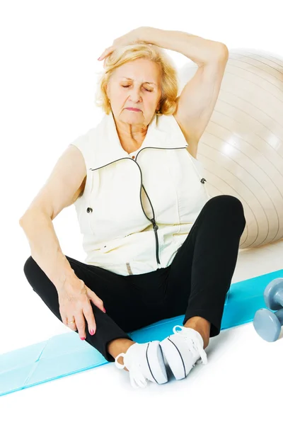 Mulher Sênior se exercitando no tapete — Fotografia de Stock