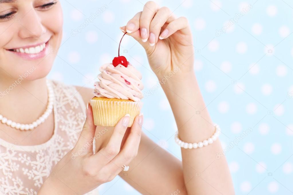 Woman eating a cupcake — Stock Photo © macniak 41486461
