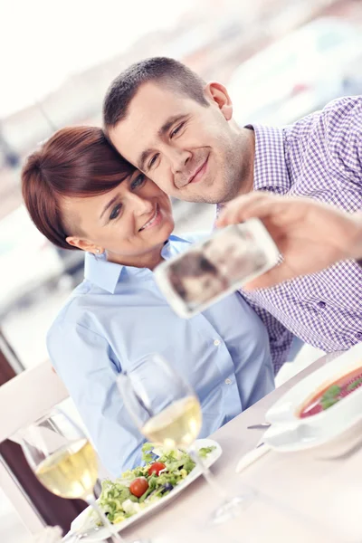 Casal jovem tirando uma foto em um restaurante — Fotografia de Stock