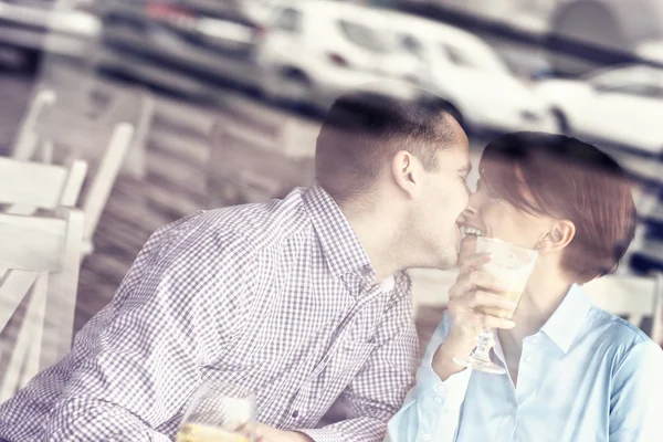 Jovem casal beijando em um restaurante — Fotografia de Stock
