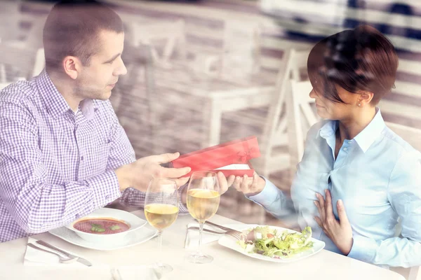 Man giving present in a restaurant — Stock Photo, Image