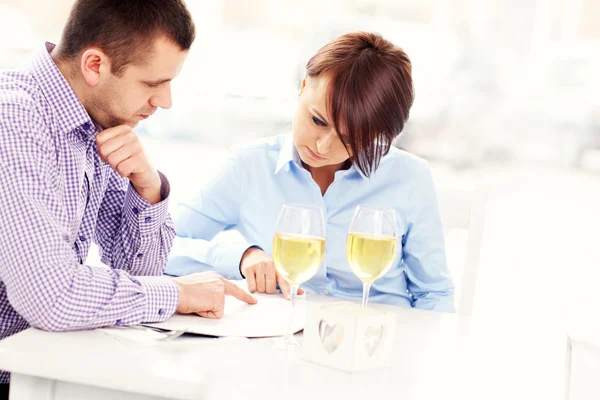 Pareja joven y menú — Foto de Stock