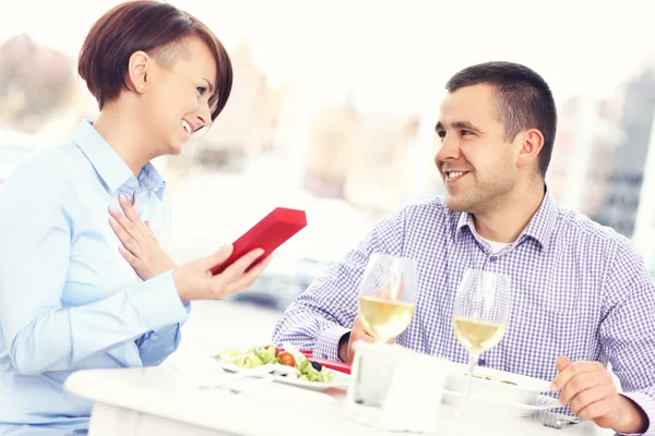 Hermosa mujer con presente en un restaurante — Foto de Stock