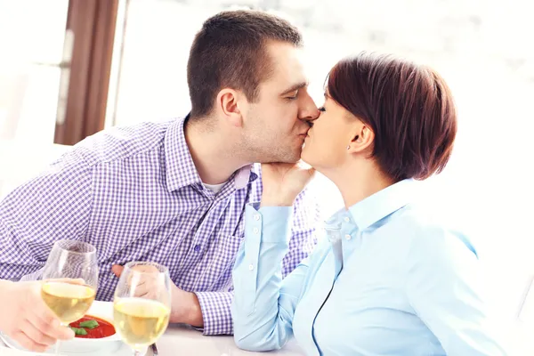 Kissing couple in a restaurant Stock Photo