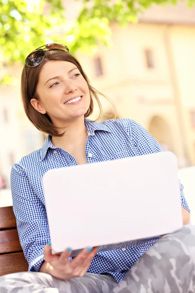 Młoda kobieta w parku z laptopa — Zdjęcie stockowe