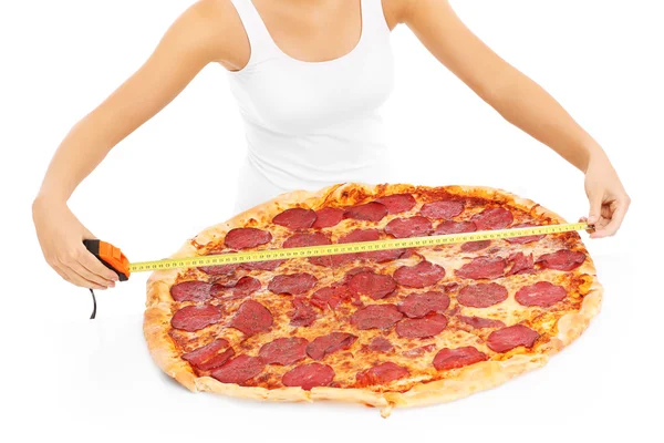 Woman measuring huge pizza — Stock Photo, Image