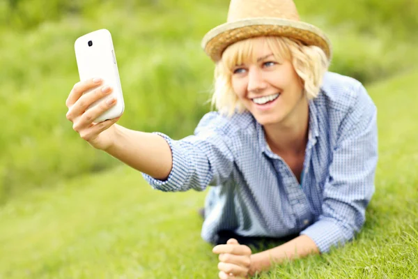 Vrouw die selfie op het gras — Stockfoto