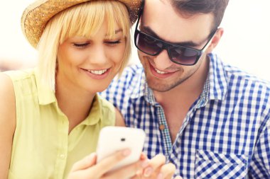 genç bir çift bir cep telefonu kullanarak