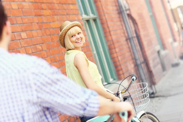 Jonge vrouw met haar vriendje fietsen — Stockfoto