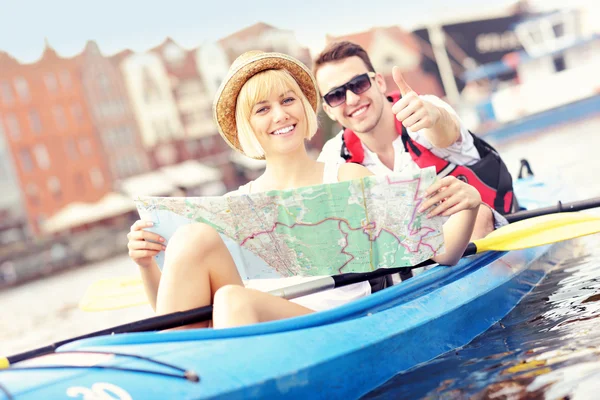 Jóvenes turistas con un mapa en canoa — Foto de Stock