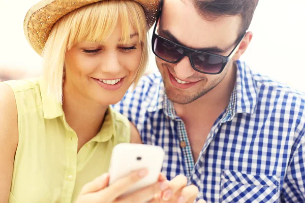 Casal jovem usando um celular — Fotografia de Stock