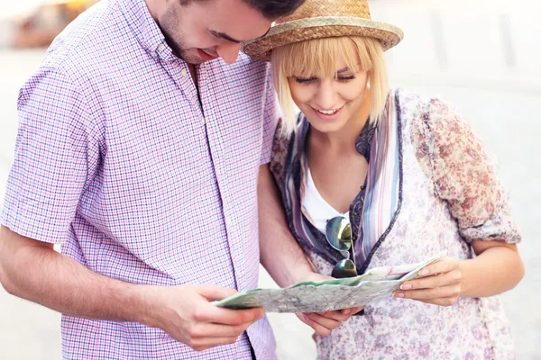 Happy tourists with a map — Stock Photo, Image