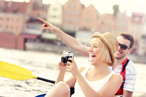 Casal feliz tirando fotos em uma canoa — Fotografia de Stock