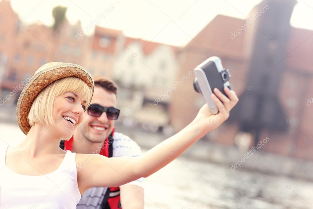 Happy couple taking pictures in a canoe