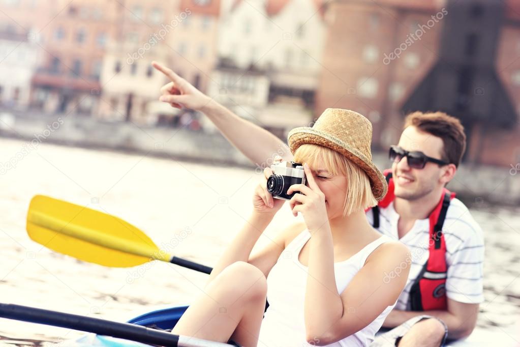 Young tourists taking pictures in a canoe