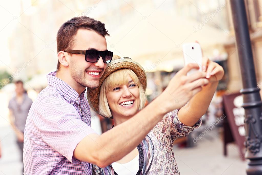 Happy couple taking a picture of themselves while sightseeing