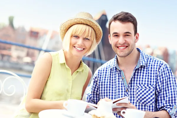 Young tourists with a guide in a cafe — Stock Photo, Image